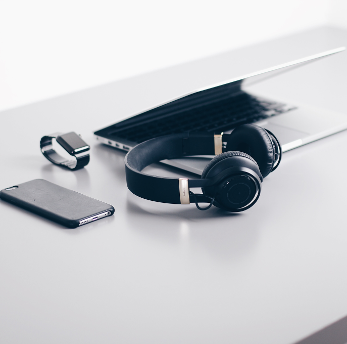 Headphones, phone and laptop on a desk