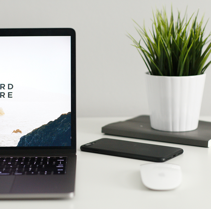 Laptop, phone and a plant on a desk